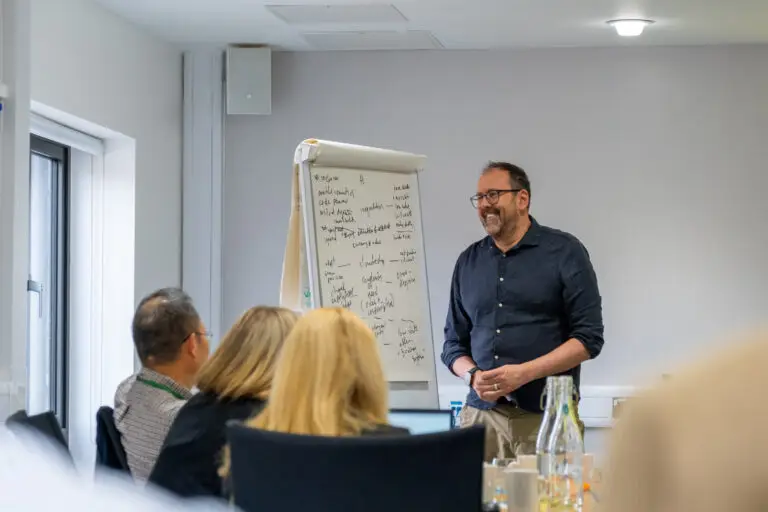 A futures planning workshop, a faciliatator is smiloing in response to an delegates comments